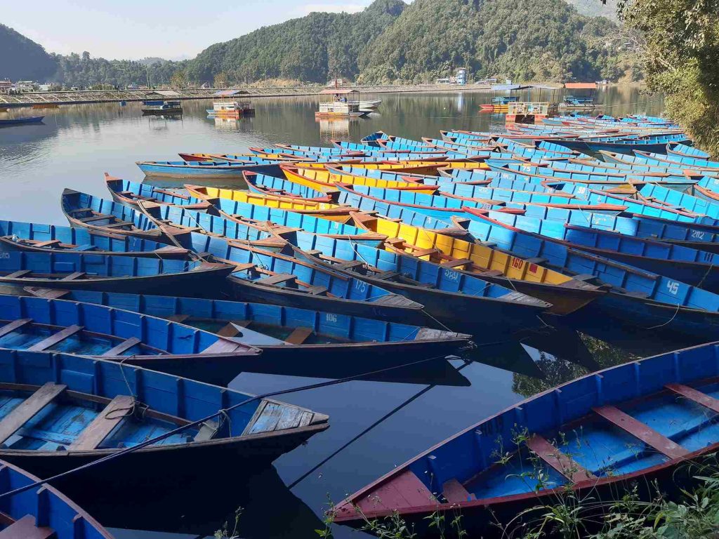 Traditional wooden boats lined up on Begnas Lake near Pokhara, a scenic highlight of the Best Hiking Trails Around Pokhara Valley.