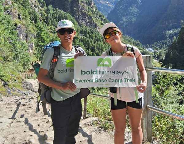 Trekkers with a banner on the Everest Base Camp Trek 13 days between Phakding and Monjo in the Dudh Koshi Valley