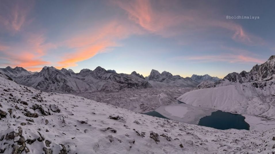 Snow-covered Gokyo Lakes shimmering beneath icy winds with rugged mountains in the background