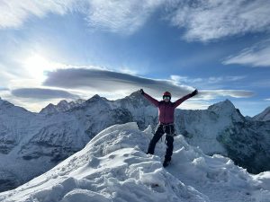 Climber ascending snowy slopes towards the Island Peak summit.