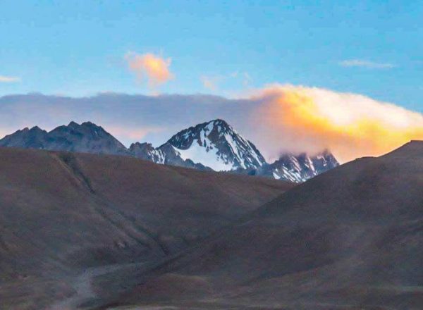 Mount Kailash region mountains with snow patches and golden sunlight, seen during Mount Kailash Mansarovar Tour via Hilsa