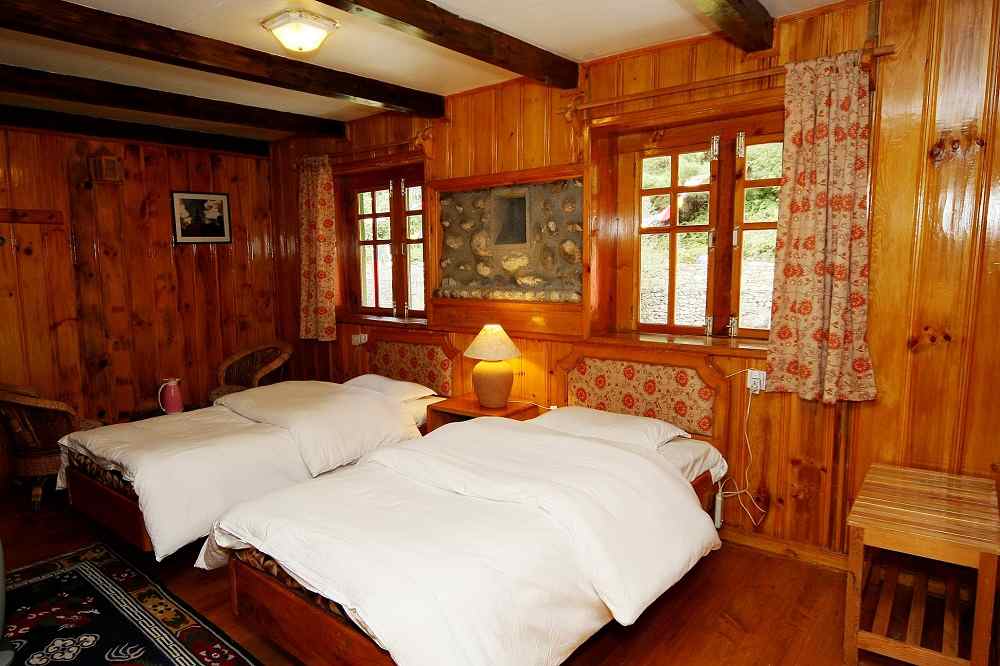 Luxury lodge room at Everest Base Camp trek with wooden interiors and twin beds