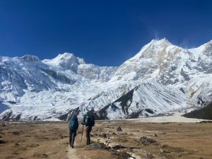 Two trekkers walk across the high-altitude valley of the 8 days Manaslu Circuit Trek