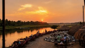 Golden sunset reflecting on the calm waters of the Rapti River in Chitwan National Park, Nepal.