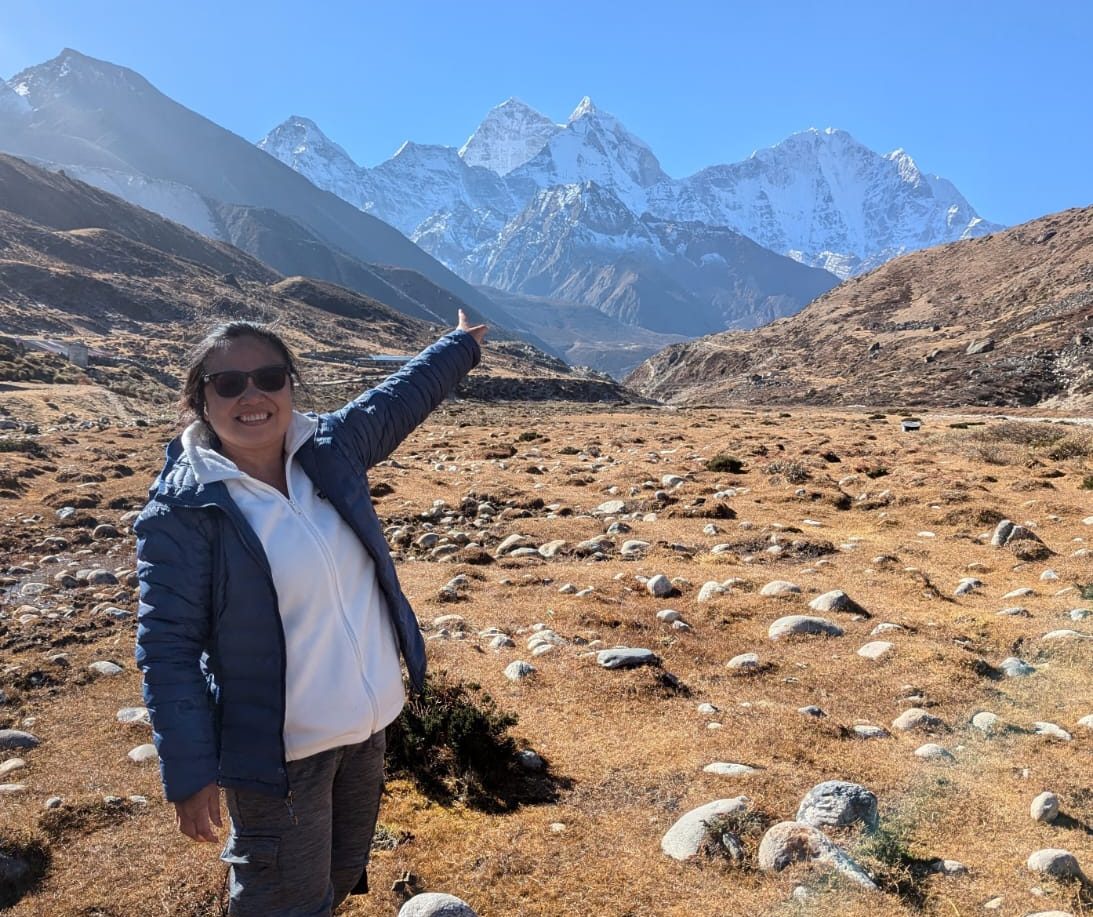 Woman pointing at Himalayan peaks in the Everest region during trekking