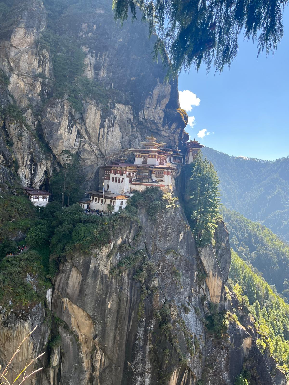 Paro Taktsang (Tiger’s Nest Monastery) perched on a dramatic cliff in Bhutan, surrounded by lush forest and mountains, featured in a Bhutan Tour 5 Days 4 Nights itinerary.