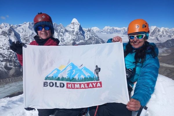 Successful summit moment during the Everest Base Camp Trek with Island Peak Climbing, as climbers celebrate with Bold Himalaya’s flag against the breathtaking backdrop of the Everest region’s snow-covered Himalayan peaks.