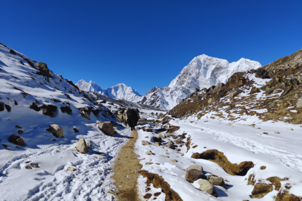 Trekking trail surrounded by snow-covered landscapes and towering Himalayan peaks on the Kanchenjunga Base Camp Trek.Helicopter Tours from Kathmandu