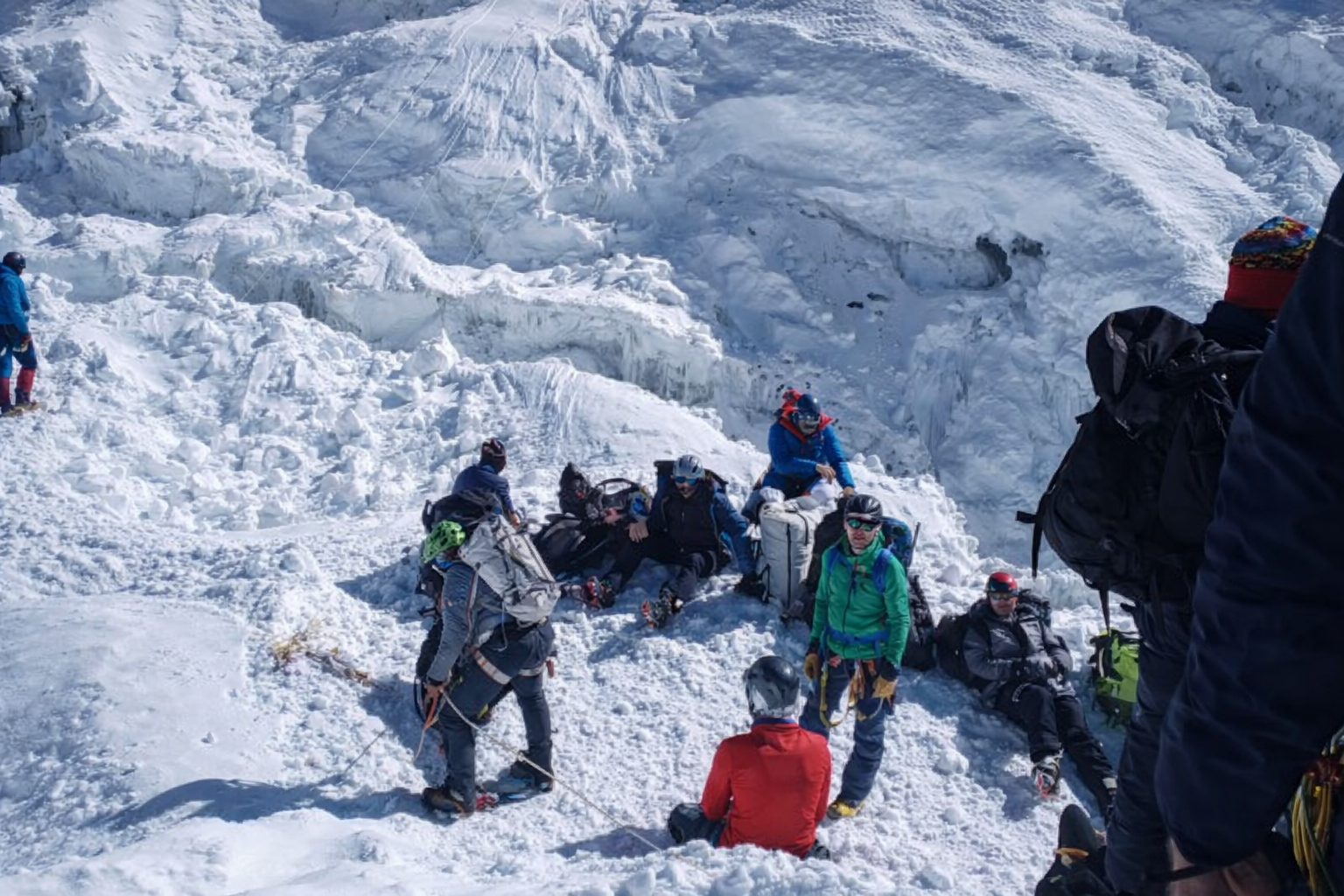 Mountaineers taking a rest on a snowy glacier during Lobuche Peak Climbing in the Everest region of Nepal.
