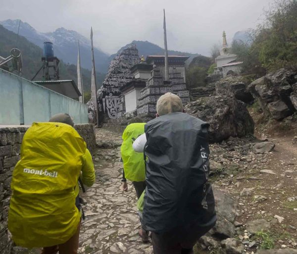 Climbers trekking past a Buddhist monastery during Lobuche Peak Climbing in the Everest region of Nepal.