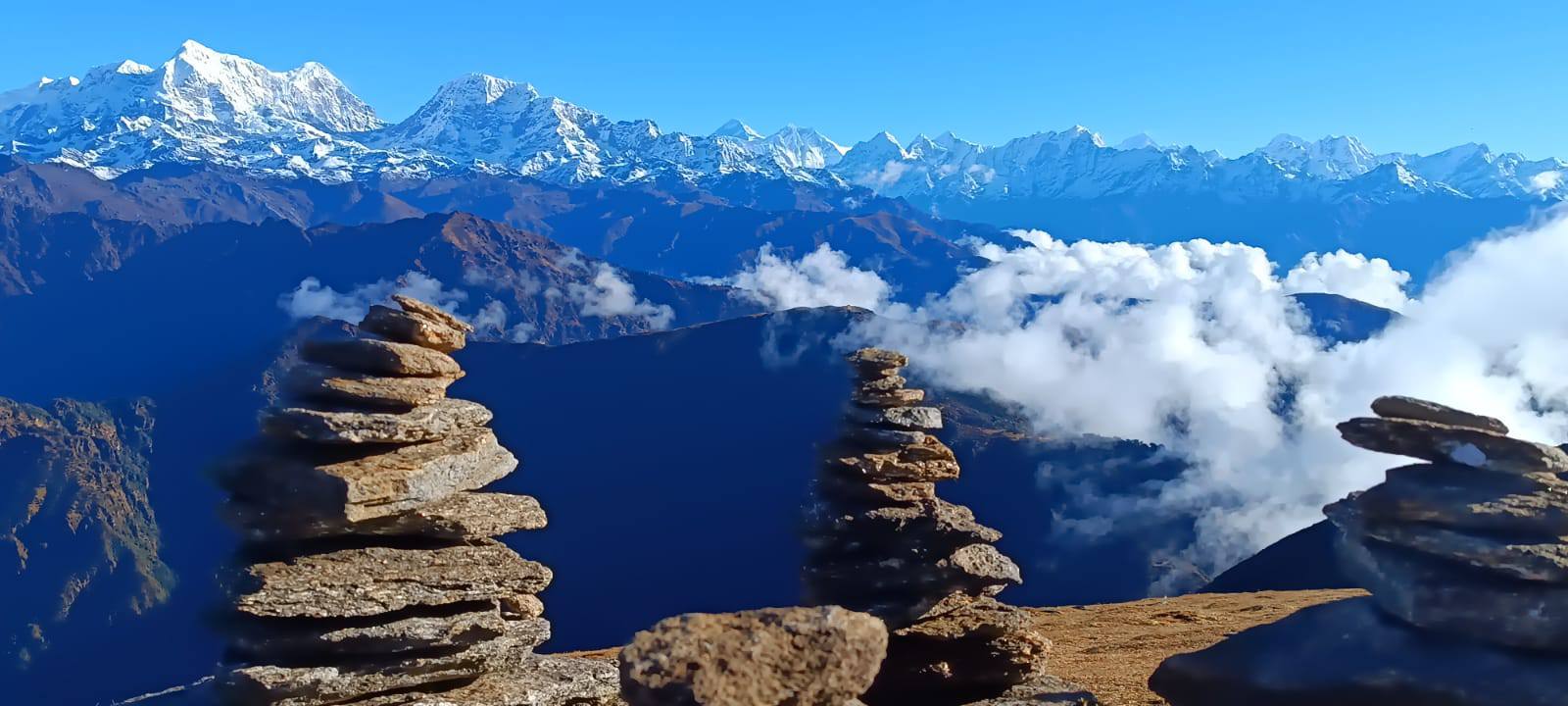 Stone cairns overlooking the Himalayan mountain range from the Pikey Peak viewpoint on a clear day.