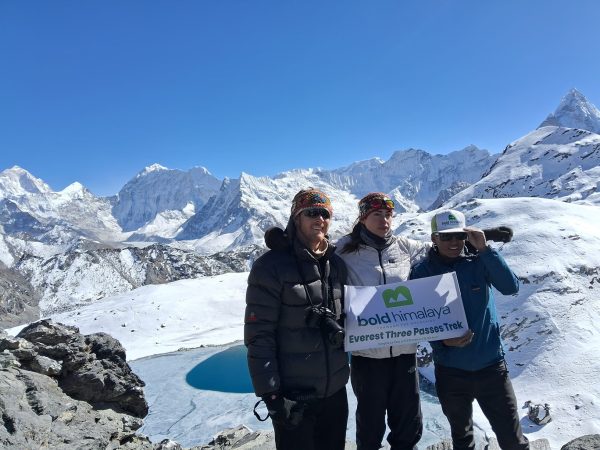 Trekkers at Gokyo Lakes Renjo La Pass Trek with snowy Himalayan mountains and glacier lake in Everest region Nepal