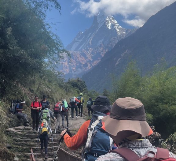 Trekkers crossing a suspension bridge on the way to Annapurna Base Camp with Mount Fishtail (Machhapuchhre) in the backdrop
