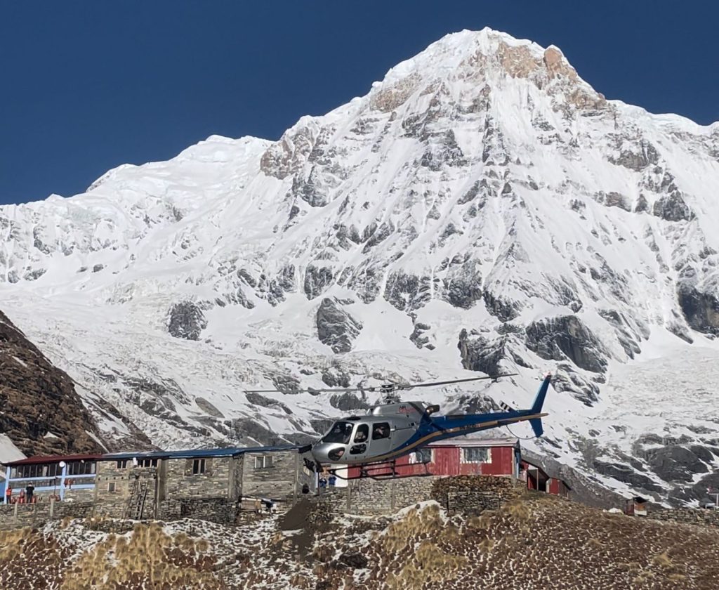 Helicopter flying at Annapurna Base Camp amidst snow-capped peaks, during the helicopter ride in Nepal