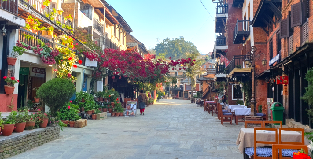 Scenic street view of Bandipur, one of the best tourist places to visit in Nepal, featuring traditional architecture, colorful flowers, and outdoor cafes