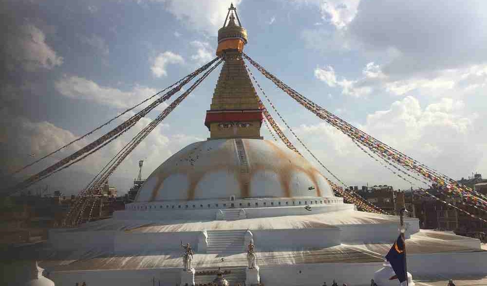 Boudhanath Stupa in Kathmandu, adorned with colorful prayer flags, showcases spiritual luxury and cultural heritage, as one of the luxurious things to do in Nepal
