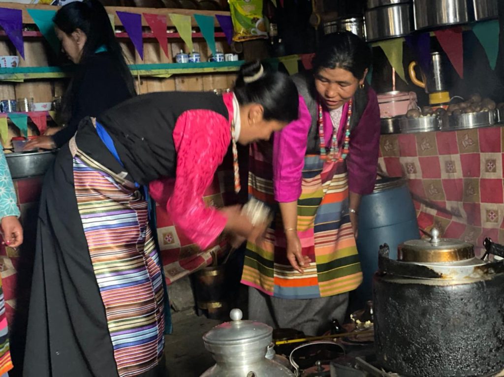 Rai women cooking traditional food inside a mountain teahouse during the Kanchenjunga Base Camp Trek in eastern Nepal.