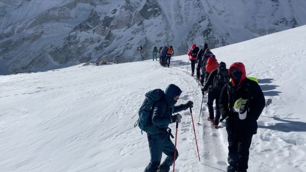 Trekkers walking in a line on an icy trail during the Manaslu Circuit Trek in Nepal