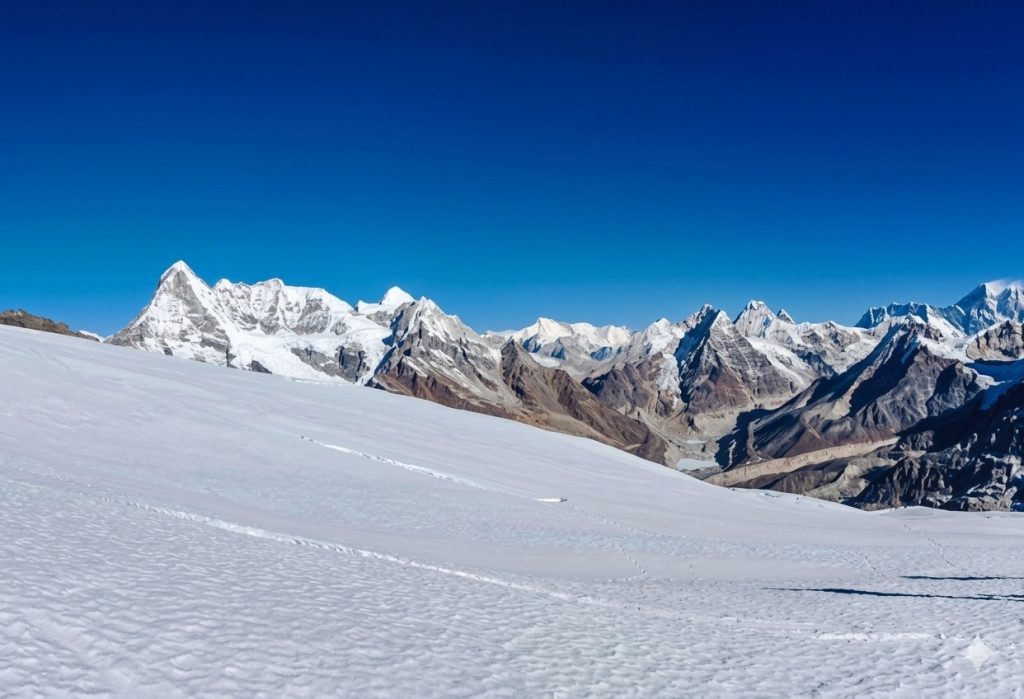 White snow and tall mountains under a clear blue sky during Mera Peak Climbing
