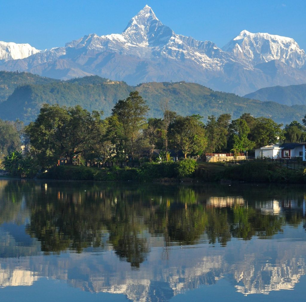 Reflection of Mount Machhapuchhre over the calm waters of Phewa Lake in Pokhara, one of the most iconic places to visit in Pokhara for natural beauty