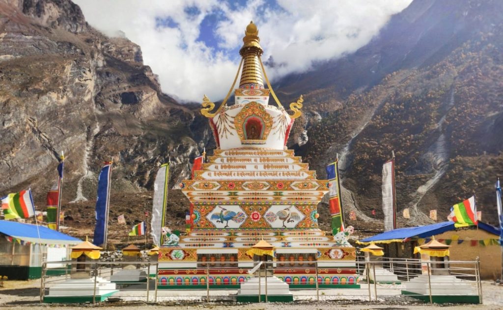 Rachen Gompa in the Tsum Valley Trek region featuring ancient murals, vibrant prayer flags, and stunning Himalayan scenery