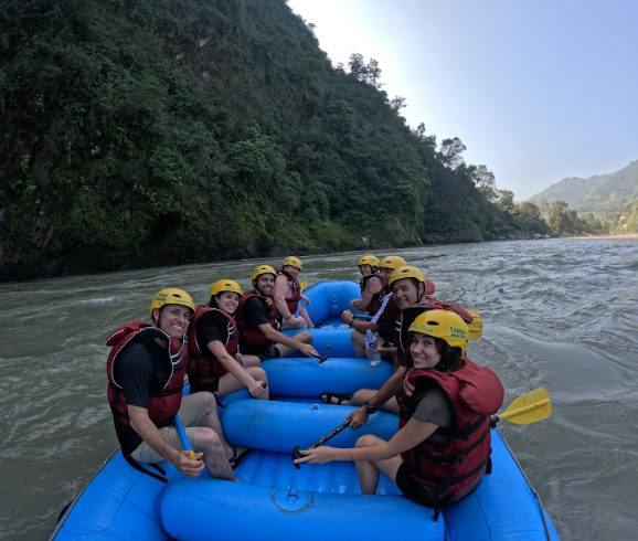 Rafters relaxing on the riverbank during a break on the Trishuli River, one of the beginner friendly rafting in Nepal