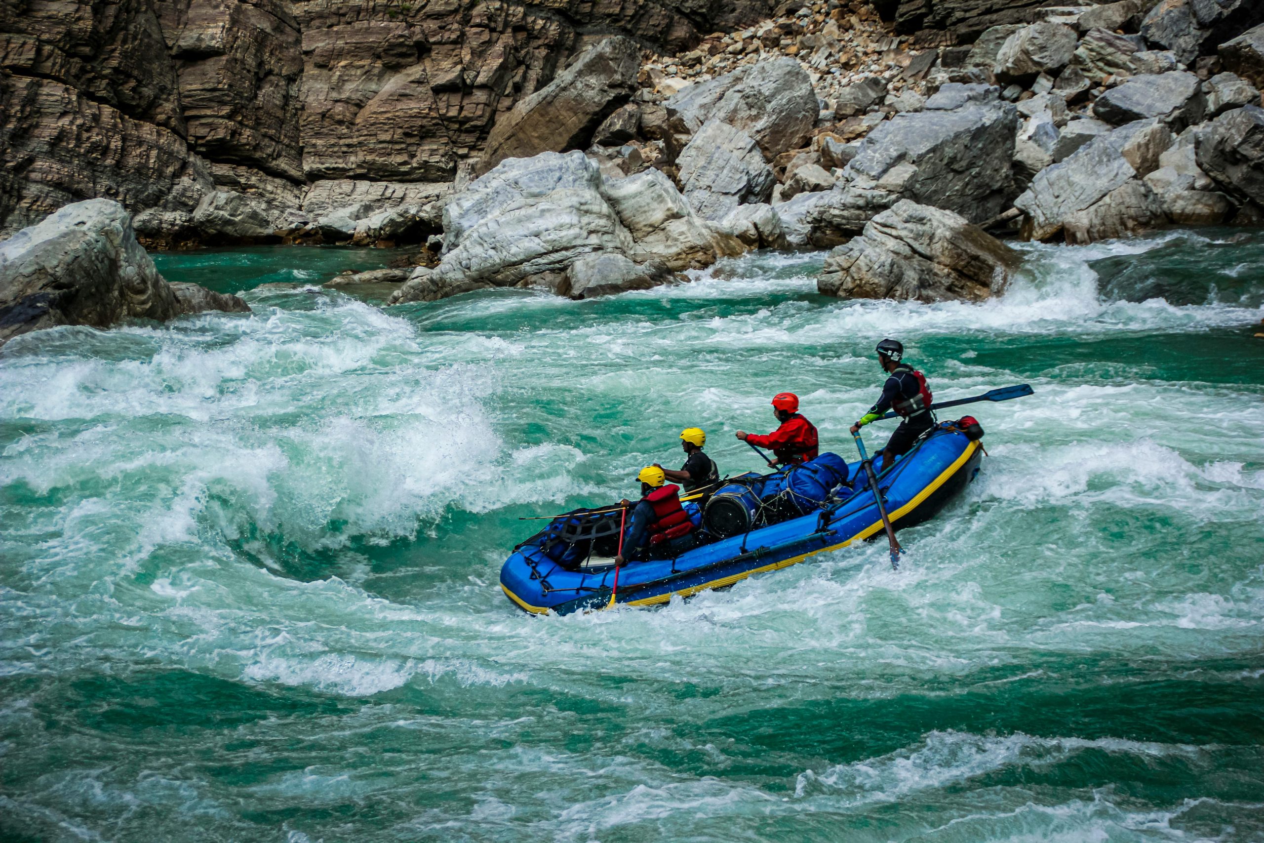 Adventurers go white-water rafting in Nepal through powerful turquoise rapids on a Himalayan river