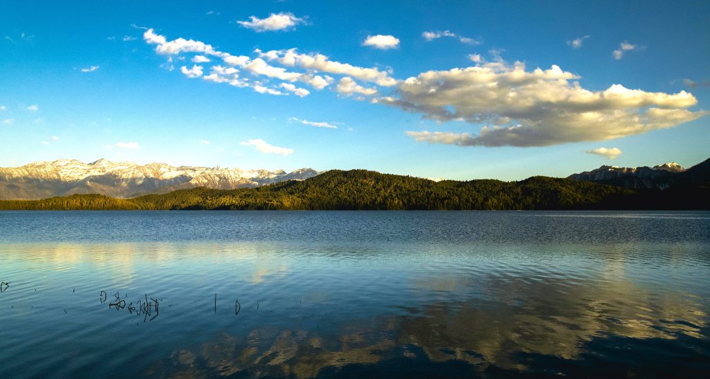 Stunning view of Rara Lake, one of the best tourist places to visit in Nepal, surrounded by mountains and lush greenery