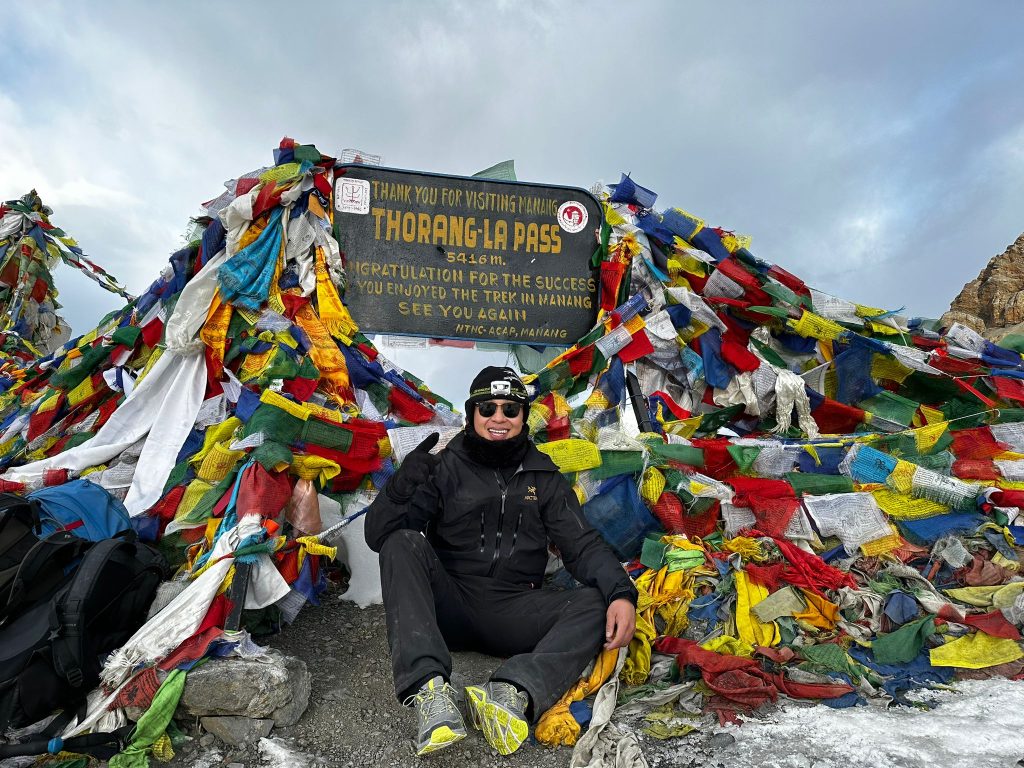 Prayer flags fluttering at the summit of Thorong La Pass, one of the best high pass treks in Nepal