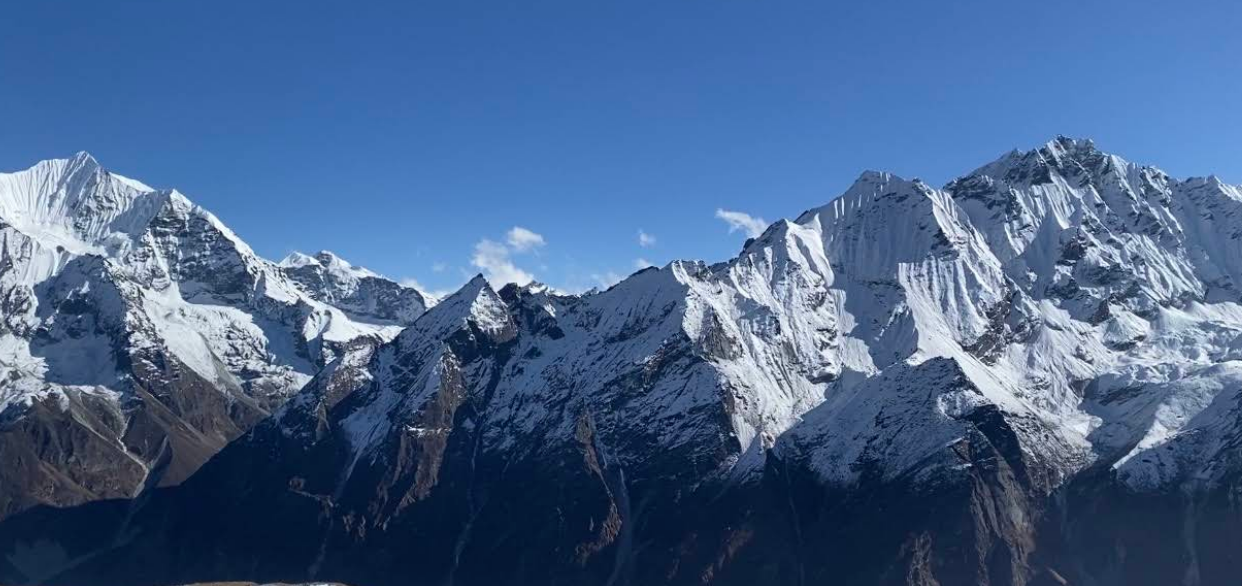 Snow-covered Himalayan mountain range under a clear blue sky during Yala Peak Climbing in the Langtang region of Nepal.