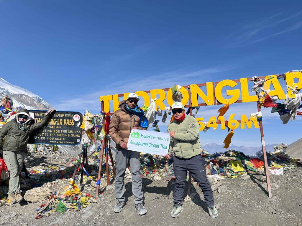 Trekkers standing at Thorong La Pass (5,416m) during the Annapurna Circuit Trek, one of the best treks in Nepal.