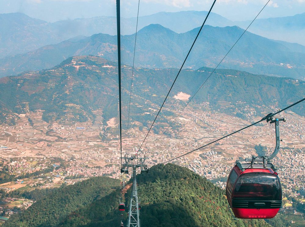 Chandragiri Hills cable car gliding above lush green hills with panoramic views of Kathmandu Valley, offering a luxurious sightseeing experience in Nepal