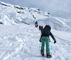Mountaineers ascending a snowy ridge toward Island Peak’s summit