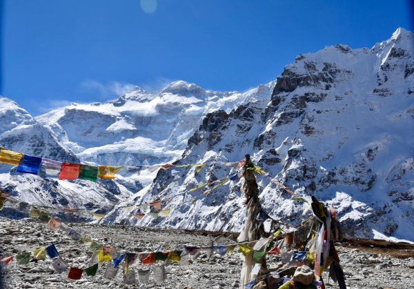 Prayer flags flutter at Kanchenjunga Base Camp, with towering Himalayan peaks, one of the best treks in Nepal