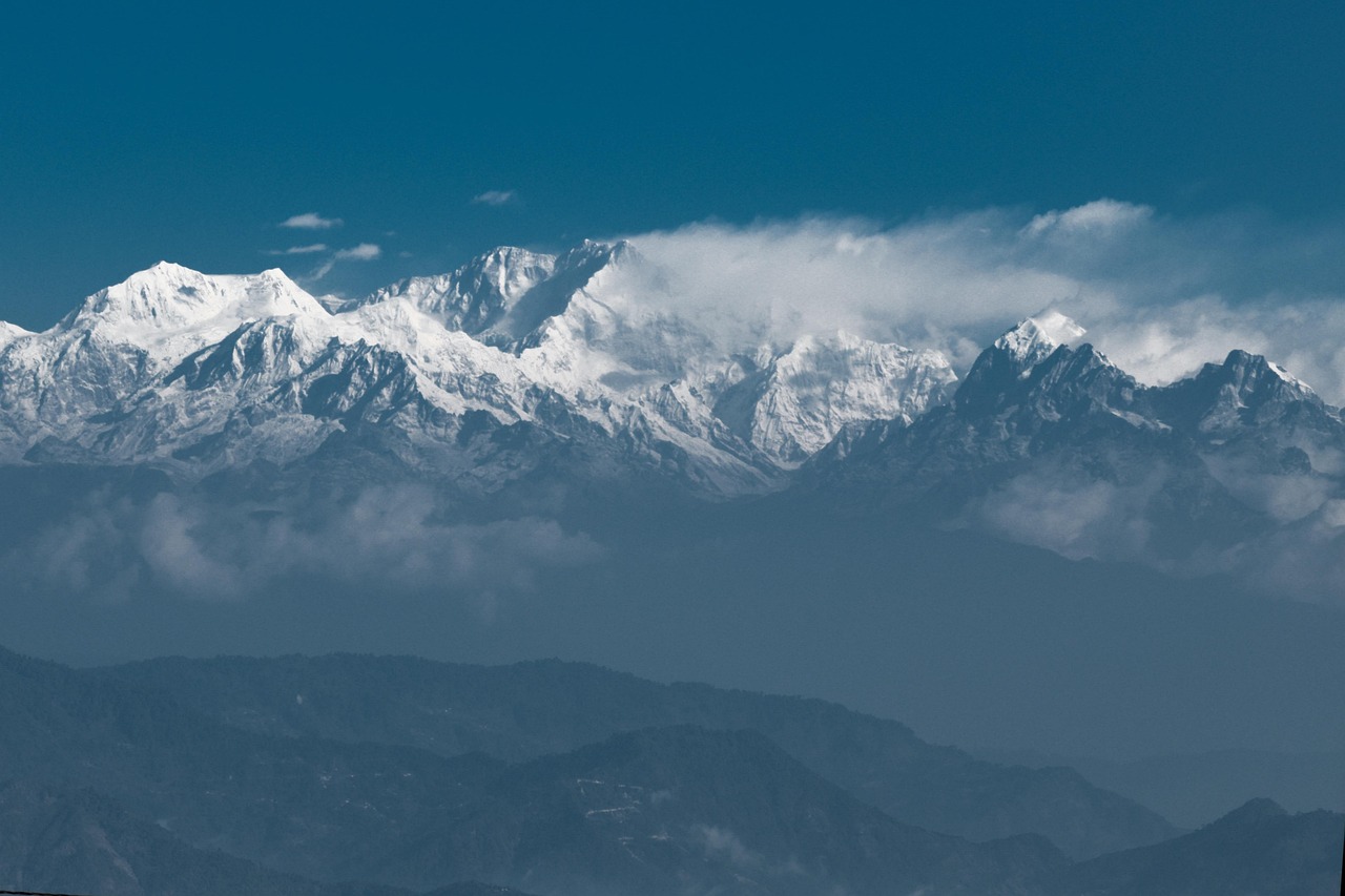Majestic Mount Kangchenjunga is wrapped in drifting clouds, creating a dramatic and mystical Himalayan landscape