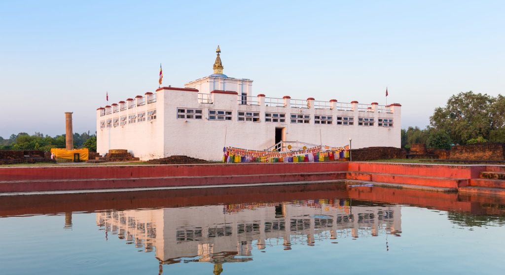 A serene view of the Maya Devi Temple in Lumbini is reflected on the sacred pond, highlighting this UNESCO World Heritage Site
