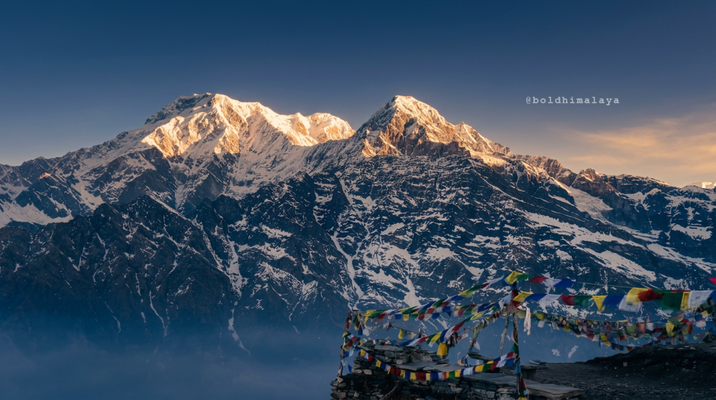 Golden sunlight rays touch the snow-covered Himalayan peaks as seen from Mardi Himal Base Camp during the early morning trek in Nepal.