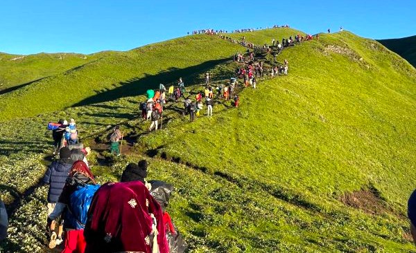 Devotees hiking together on the Badimalika Trek during monsoon treks in Nepal, and pilgrims heading toward the Badimalika Temple