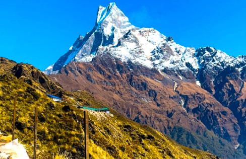 Snow-capped Machhapuchhre rising above green hills and a quiet trail on the Mardi Himal Trek during the monsoon treks in Nepal
