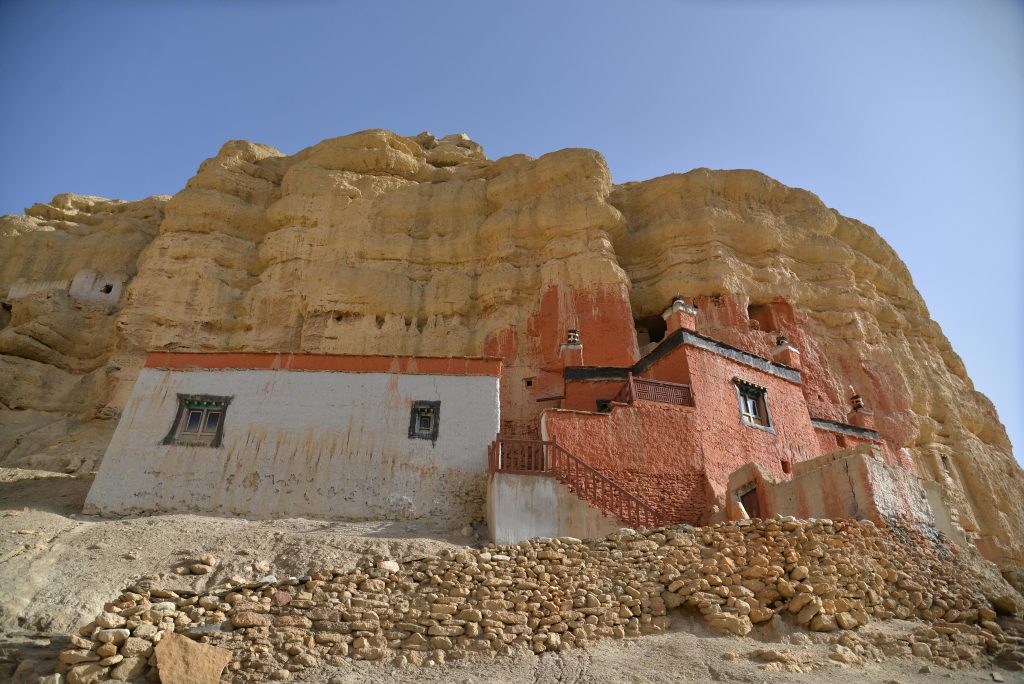 Ancient cliff-side monastery and traditional mud-brick houses in Upper Mustang, a rain-shadow region best for monsoon treks in Nepal
