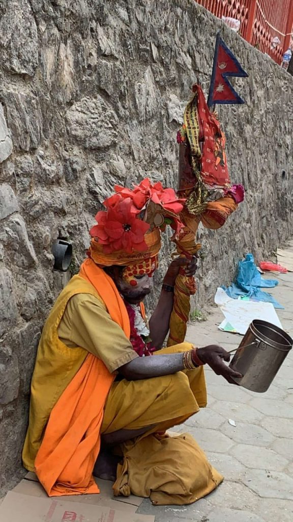 Ash-covered sadhus meditating near the Bagmati River during Maha Shivaratri at Pashupatinath Temple in Kathmandu, Nepal.