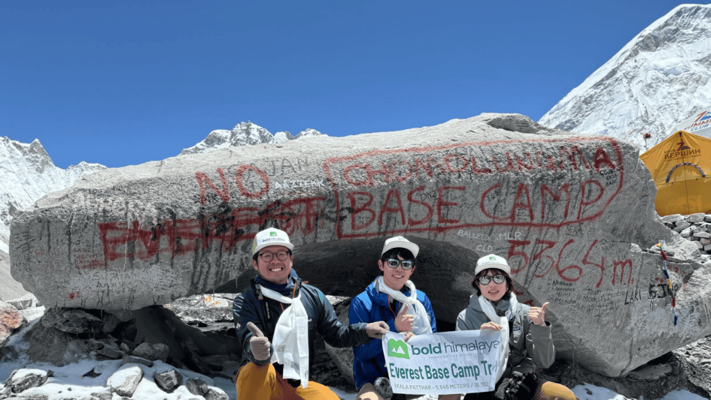 Trekkers posing at Everest Base Camp rock at Mount Everest Base Camp altitude 5364 meters