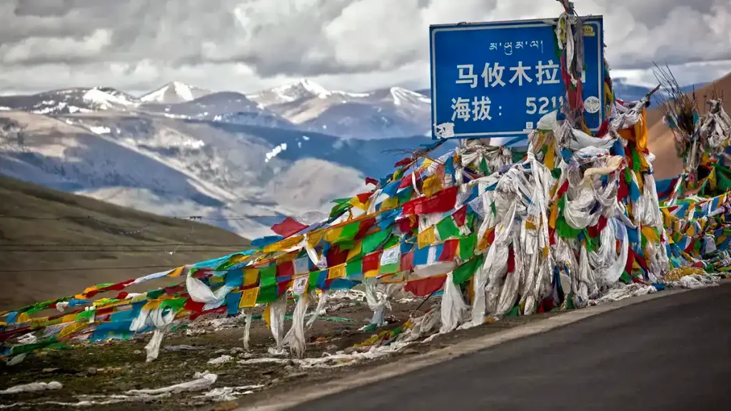 View of Mayum La Pass at 5,211 meters during the Kailash Mansarovar trek, showing snowy peaks and pilgrims walking the trail.-Helicopter vs Overland Kailash Mansarovar-Mount Kailash