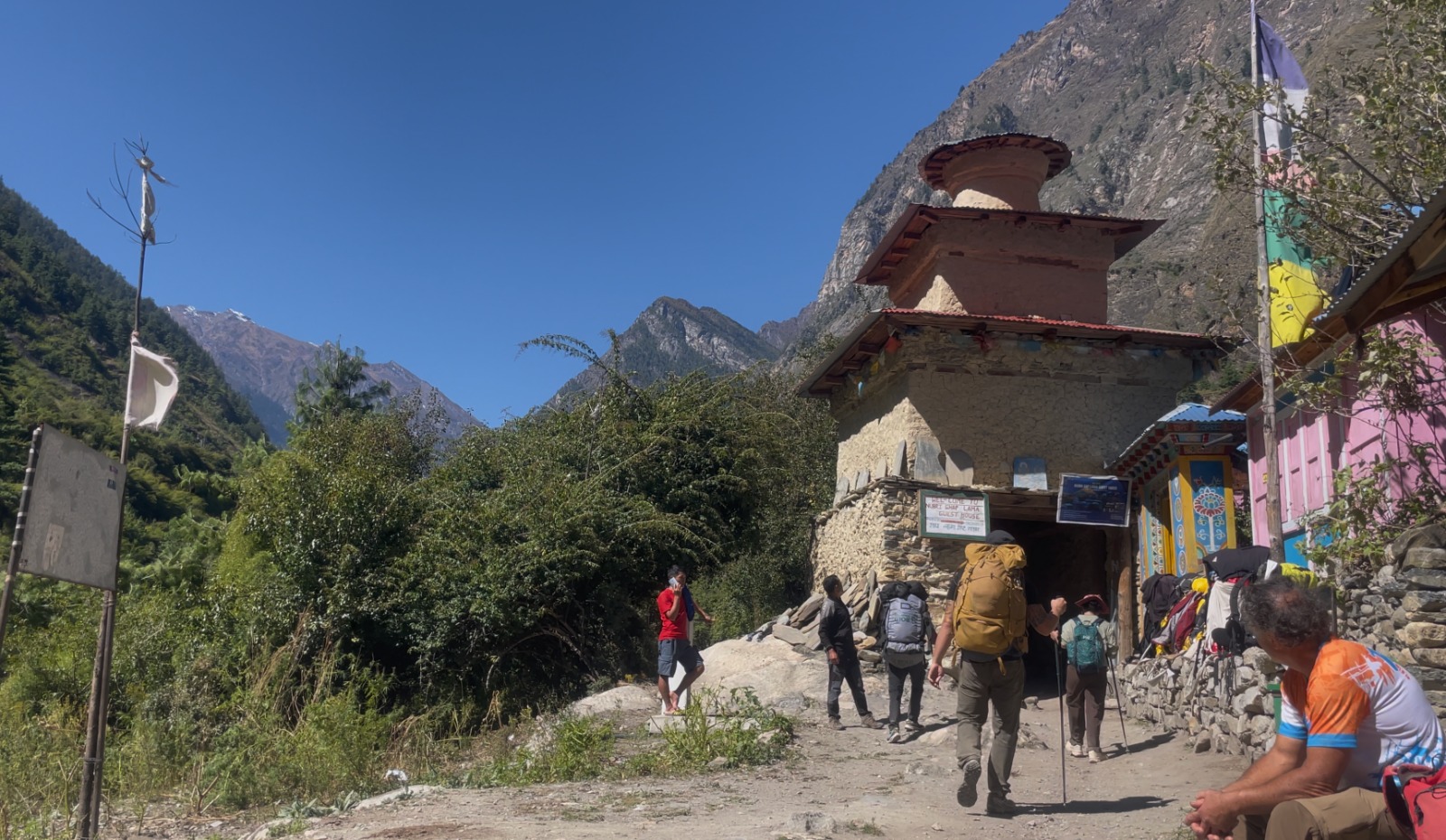 Trekkers passing through a chorten on the Manaslu Circuit Trek-Manaslu Circuit Trek Larke La Pass