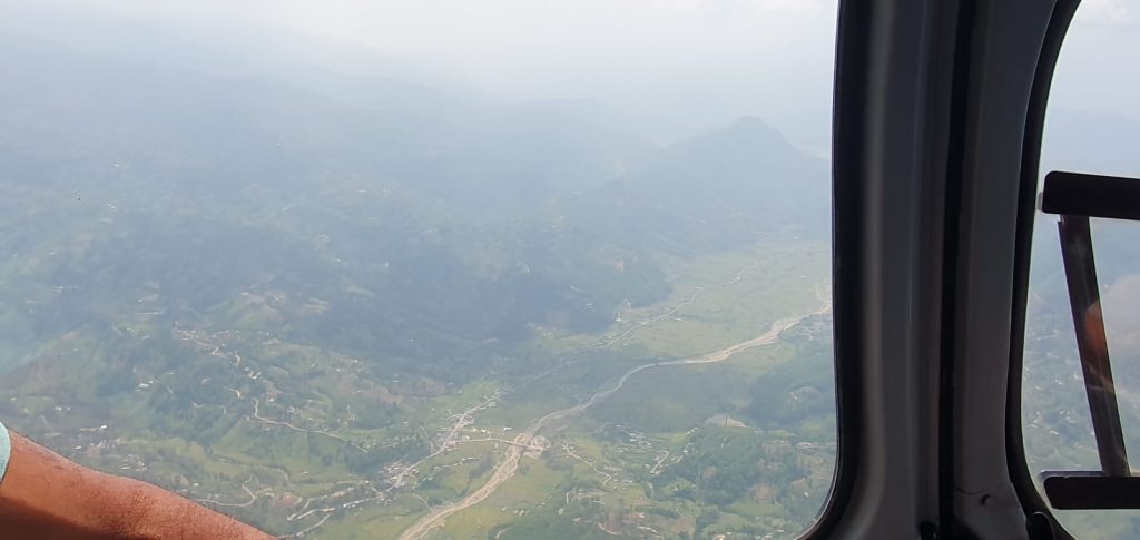 Helicopter flying above the Himalayas on the Kailash Mansarovar route, showcasing high alpine valleys, snow-capped peaks, and the dramatic landscape of Tibet as an alternative to the slower, culturally immersive overland jou-Helicopter vs Overland Kailash Mansarovar