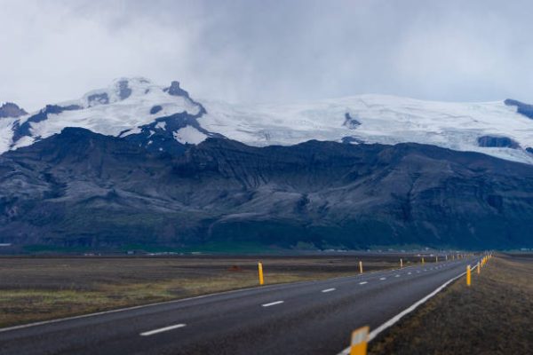 Helicopter vs Overland Kailash Mansarovar showing an open road with mountains in the background, representing the overland route compared to the aerial helicopter experience.