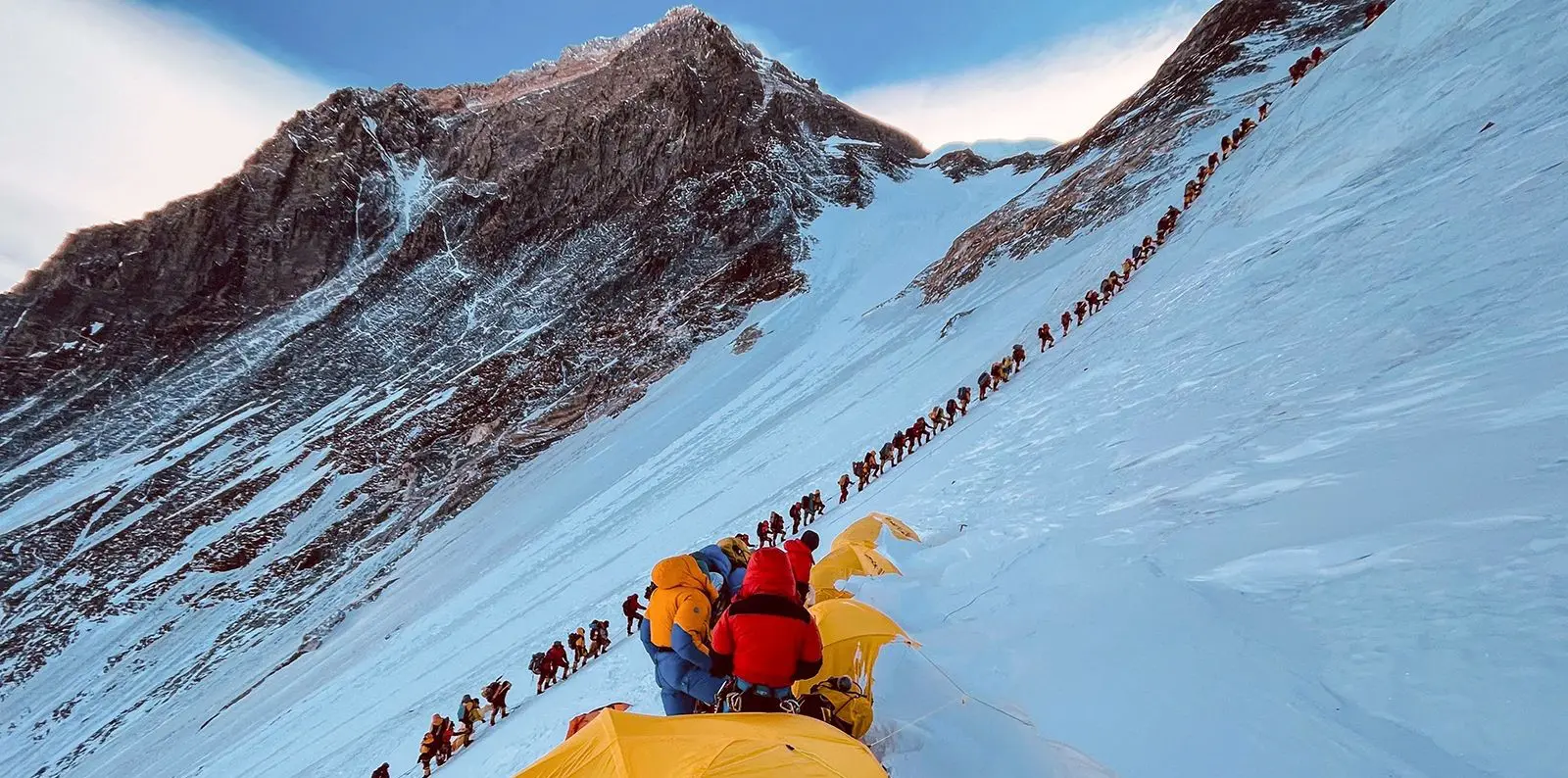 Mount Everest expedition team navigating traffic on the route during a clear day.