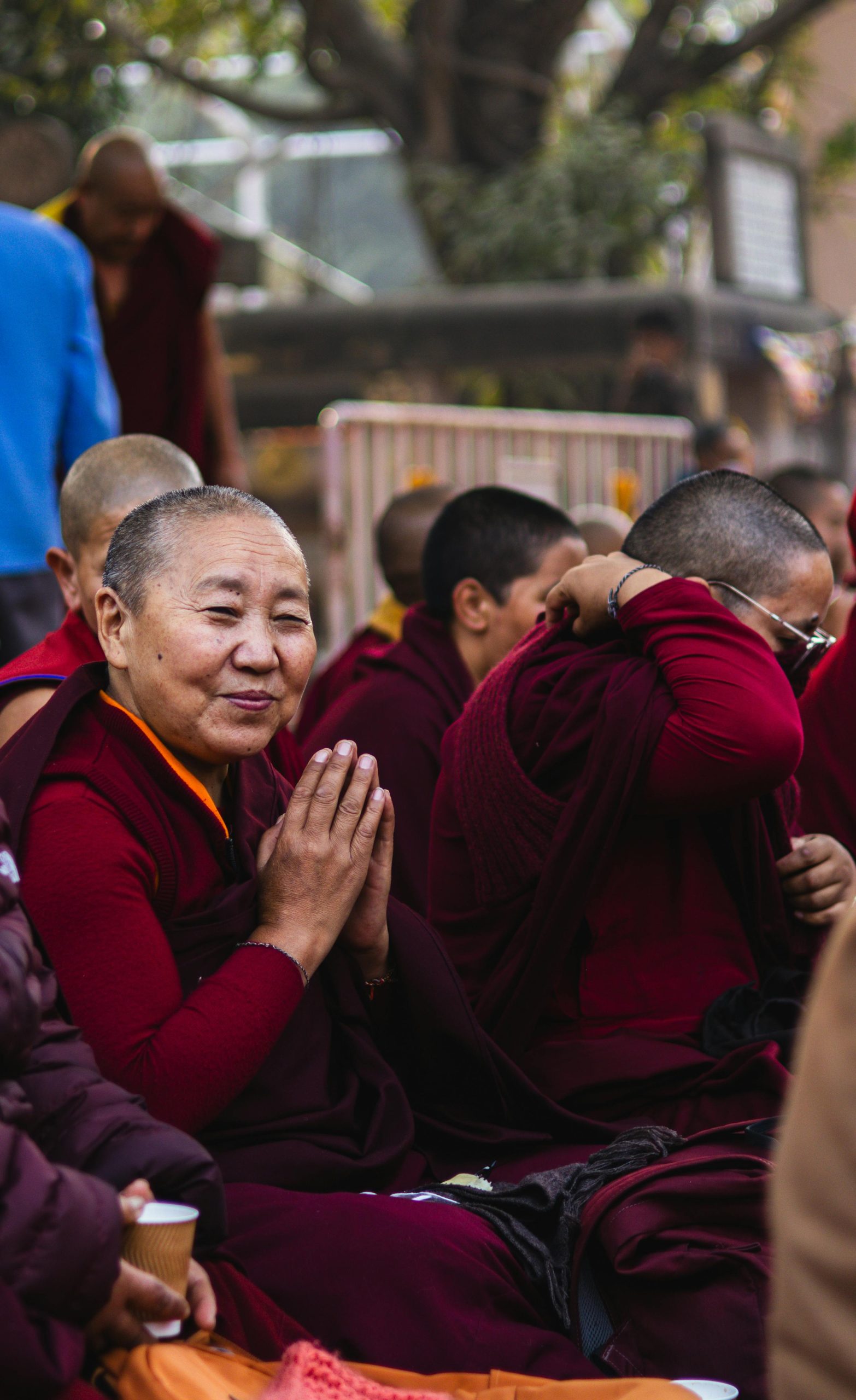 Namaste gesture in a Himalayan Buddhist setting, an elderly Buddhist nun with hands pressed together in mindful bow, symbolizing presence, humility, compassion, and conscious awareness.