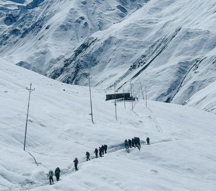 Trekkers hiking through deep snow near Thorong Phedi on the Annapurna Circuit Trek in Nepal, a high-altitude route often highlighted in comparisons of Annapurna Base Camp Trek vs Annapurna Circuit Trek.