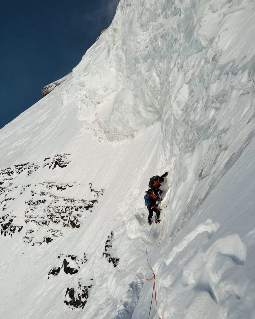 Alpinists ascending a vertical ice face on K2 in the Karakoram, highlighting the technical climbing conditions compared to Mount Everest vs K2.